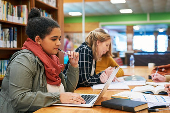 研究拍摄集中年轻的女学生工作移动PC研究内部图书馆