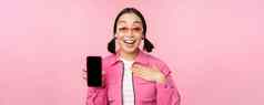 图像惊讶女孩显示移动电话应用程序屏幕智能手机显示应用程序接口站粉红色的背景
