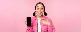 图像惊讶女孩显示移动电话应用程序屏幕智能<strong>手机</strong>显示应用程序接口站粉红色的背景
