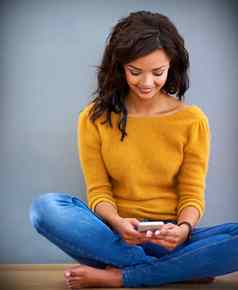 分享幸福技术拍摄年轻的女人坐着地板上移动电话