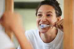 健康的牙齿刷一天拍摄年轻的女人刷牙牙齿浴室镜子