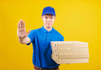 交付服务男人。穿蓝色的t恤帽统一的持有<strong>纸盒子</strong>意大利披萨包显示手停止标志手势