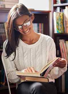 图书馆最喜欢的的地方拍摄年轻的女人阅读书图书馆