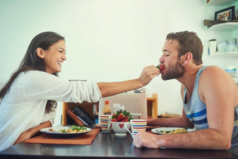 浆果英国宇航系统公司拍摄快乐年轻的女人喂养草莓的男朋友早餐表格