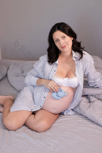 快乐漂亮的女人享受怀孕妈妈。期待父可爱的大肚子怀孕了浅黑肤色的女人光房间