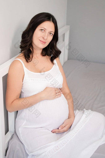 快乐漂亮的女人享受怀<strong>孕妈妈</strong>。期待父可爱的大肚子怀孕了浅黑肤色的女人光房间