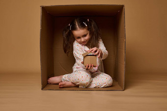 可爱的孩子女孩隐藏内部盒子玩工艺纸板房子模型真正的房<strong>地产</strong>住房保险社会安全概念复制空间<strong>广告</strong>
