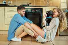 他婴儿拍摄年轻的夫妇支出时间小狗坐着厨房地板上