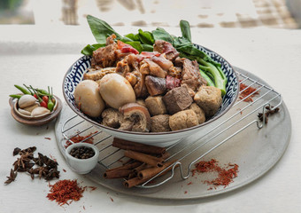 红烧猪肉腿煮熟的鸡蛋豆腐甘蓝陶瓷碗服务大蒜guinea-peppers白色背景