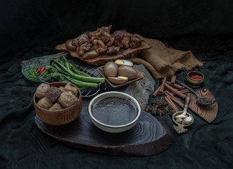 红烧猪肉腿煮熟的鸡蛋豆腐甘蓝甜蜜的肉汁酱汁香料黑暗背景