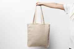 女手持有生态可重用的购物袋白色背景
