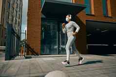 女运动员运行在户外穿保护面具白天