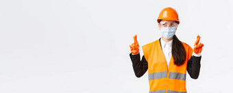 科维德安全协议企业建设防止病毒概念充满希望的乐观亚洲女工程师头盔脸面具使左很高兴交叉手指