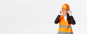 微笑漂亮的女亚洲工程师建设经理安全头盔眼镜协议enterting建筑区域企业站白色背景
