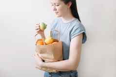 购物健康的吃生态友好的概念关闭女人持有生态袋水果白色背景