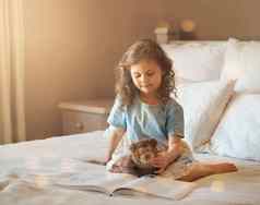 书重要的孩子们拍摄可爱的女孩首页阅读故事书床上Teddybear