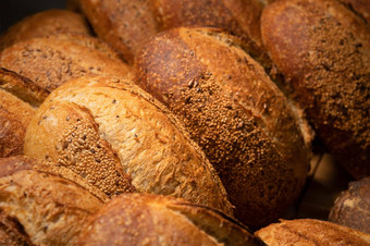 酵母面包特写镜头新鲜烤轮面包金地壳面包店货架上上下文德国面包店乡村分类面包