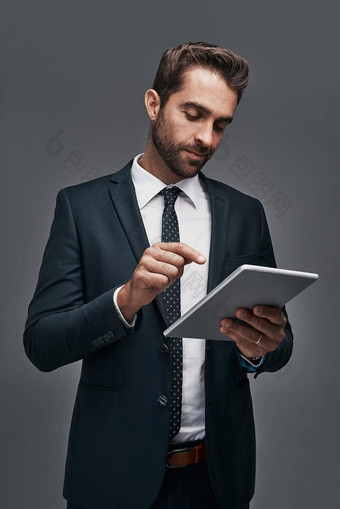 有关企业世界工作室拍摄英俊的年轻的商人数字平板电脑灰色背景