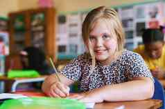 急切的学习拍摄年轻的女孩坐着教室学校写作工作簿