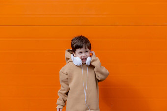 男孩听音乐耳机背景橙色墙复制空间模型文章现代孩子们文章现代音乐文章选择耳机