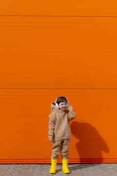 男孩听音乐耳机背景橙色墙复制空间模型文章现代孩子们文章现代音乐文章选择耳机