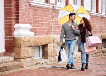 雨不会停止购物疯狂完整的长度拍摄充满深情的年轻的夫妇享受购物疯狂城市