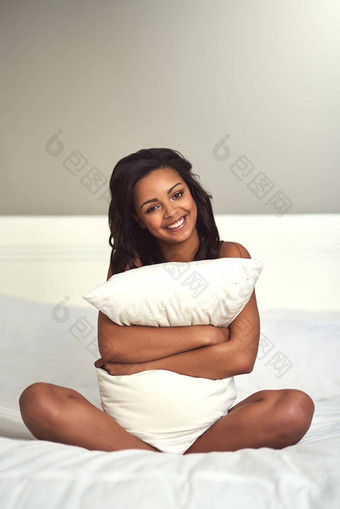 舒适的床上肖像有吸引力的年轻的女人拥<strong>抱枕</strong>头坐着床上