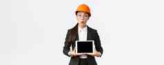 深刻的印象亚洲女建设工程师女商人安全头盔西装显示图表介绍双字母组合digial平板电脑屏幕站惊讶白色背景