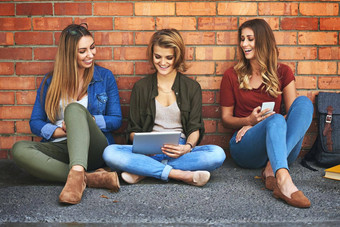 无线网络让研究校园拍摄微笑女大学学生坐着校园数字平板电脑
