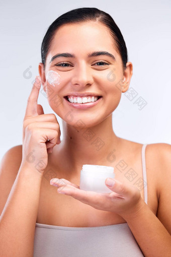 保湿霜叶子皮肤水化光滑的拍摄美丽的年轻的女人应用保湿霜脸