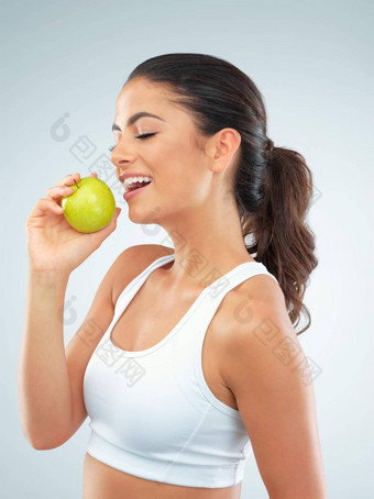 健康的身体快乐心工作室拍摄适合年轻的女人吃<strong>苹果灰色</strong>的背景
