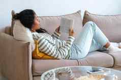 非裔美国人女休息沙发阅读书离线数字排毒