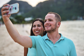 让分享家庭首页拍摄夫妇采取自拍海滩