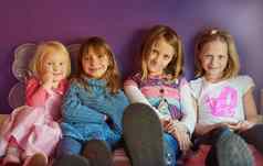 快乐的童年天肖像集团女孩坐着紫色的背景