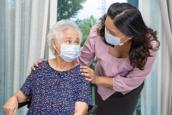照顾者亚洲高级上了年纪的夫人女人坐着轮椅穿脸面具保护安全感染科维德冠状病毒