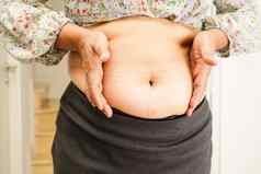亚洲女人显示脂肪肚子大大小超重肥胖办公室