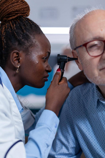 关闭医院专家检查退休男人。耳镜
