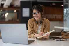 肖像年轻的亚洲女人移动PC写作使列表采取笔记记事本工作学习移动PC在室内教育培训研讨会教育在线概念