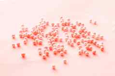 浪漫的模式粉红色的有色珠子分散软粉红色的背景节日模式婚礼设计特写镜头爱好工艺手工制作的主题