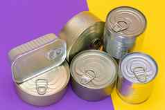 集团堆放锡罐空白边缘分裂黄色的紫罗兰色的背景