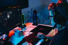 年轻的男人。上瘾在线视频游戏玩电脑年轻的玩家照亮彩色灯