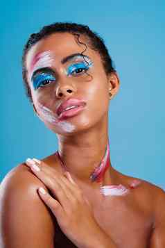 色彩鲜艳的帆布工作室肖像美丽的年轻的女人覆盖脸油漆摆姿势蓝色的背景
