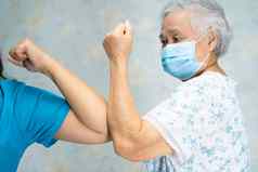 亚洲医生老病人撞肘部正常的社会距离避免科维德冠状病毒