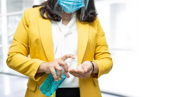 正常的亚洲工作女人洗手<strong>新闻蓝色</strong>的酒精洗手液过来这里保护安全感染杀了科维德冠状病毒办公室