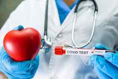积极的血感染样本测试管科维德冠状病毒实验室科学家持有红色的心鼓励病人医院