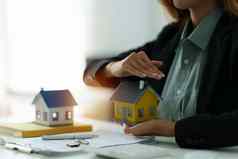 女人持有检查房子模型真正的房地产房子评估检查保险概念