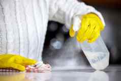 强大的消毒液拍摄女人喷涂厨房计数器清洁
