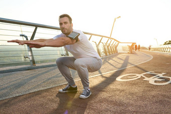 中年运动员运动员订婚了体育城市桥黎明执行深下蹲揉肌肉身体概念体育运动运动能源动态健康的生活方式