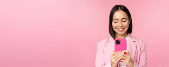 肖像微笑业务女人亚洲企业人智能手机移动电话应用程序站粉红色的背景