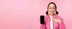 图像惊讶女孩显示移动电话应用程序屏幕智能手机显示应用程序接口站粉红色的背景